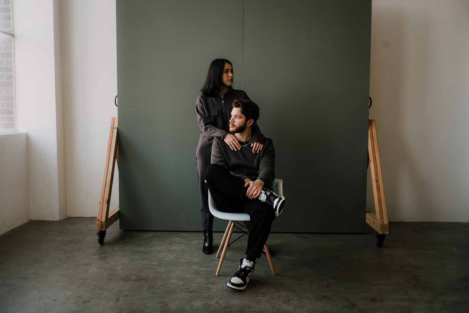 a person leaning on a person sitting in a chair